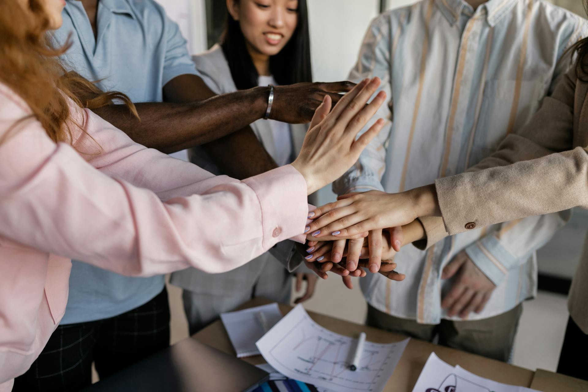 Five people holding each other's hands to show spirit of collaboration.