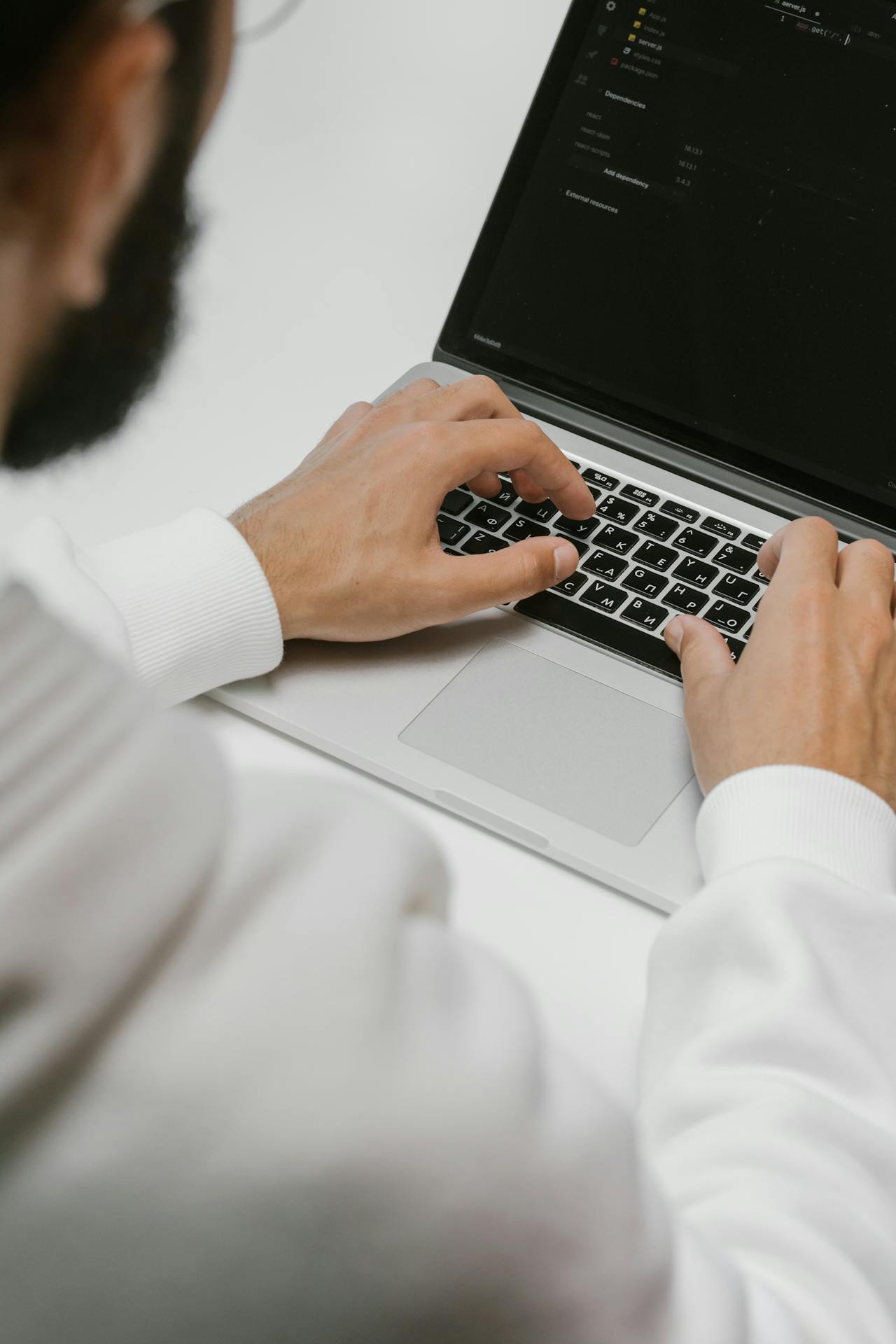 A programmer diligently coding on his laptop.