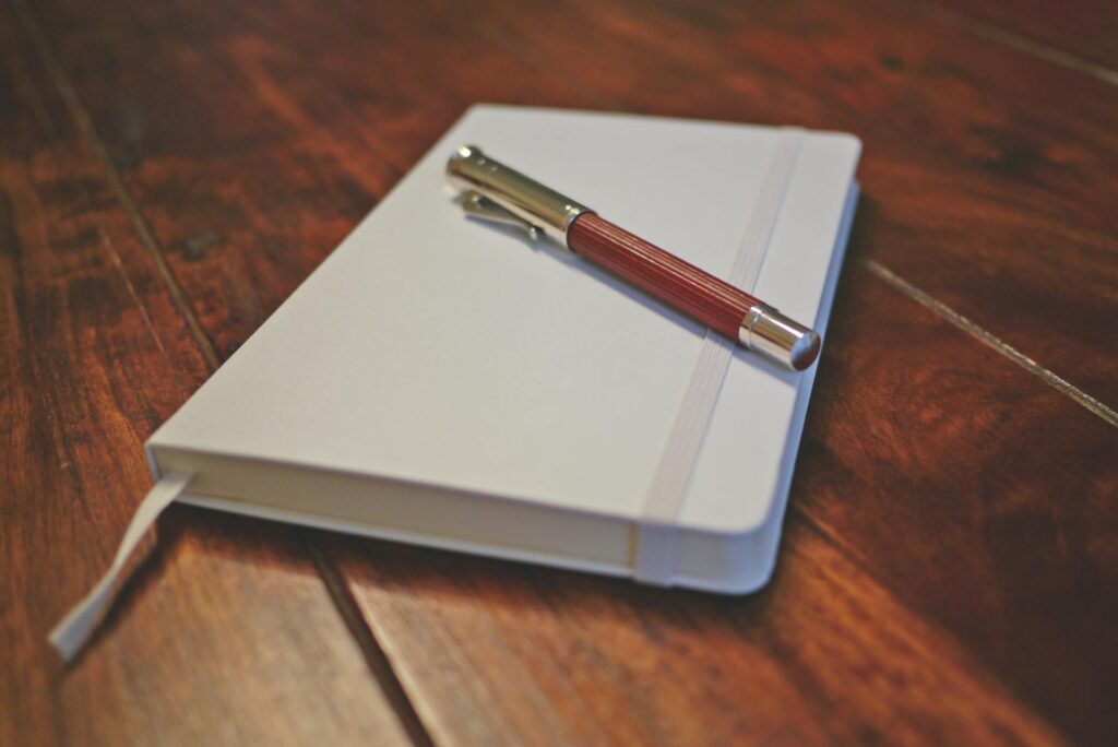 A logbook with a pen next to it.